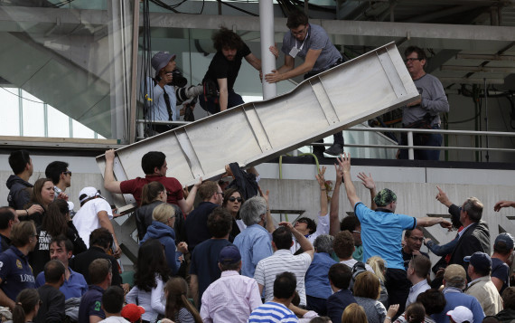 People remove a piece of metal which fell on a stand of center court as France's Jo-Wilfried Tsonga plays Japan's Kei Nishikori during their quarterfinal match of the French Open tennis tournament at the Roland Garros stadium, Tuesday, June 2, 2015 in Paris, France. (AP Photo/Thibault Camus)